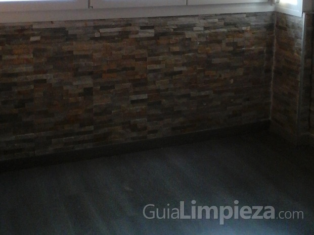 Colocación de parquet, pared con revestimiento de piedra natural y limpieza a fondo